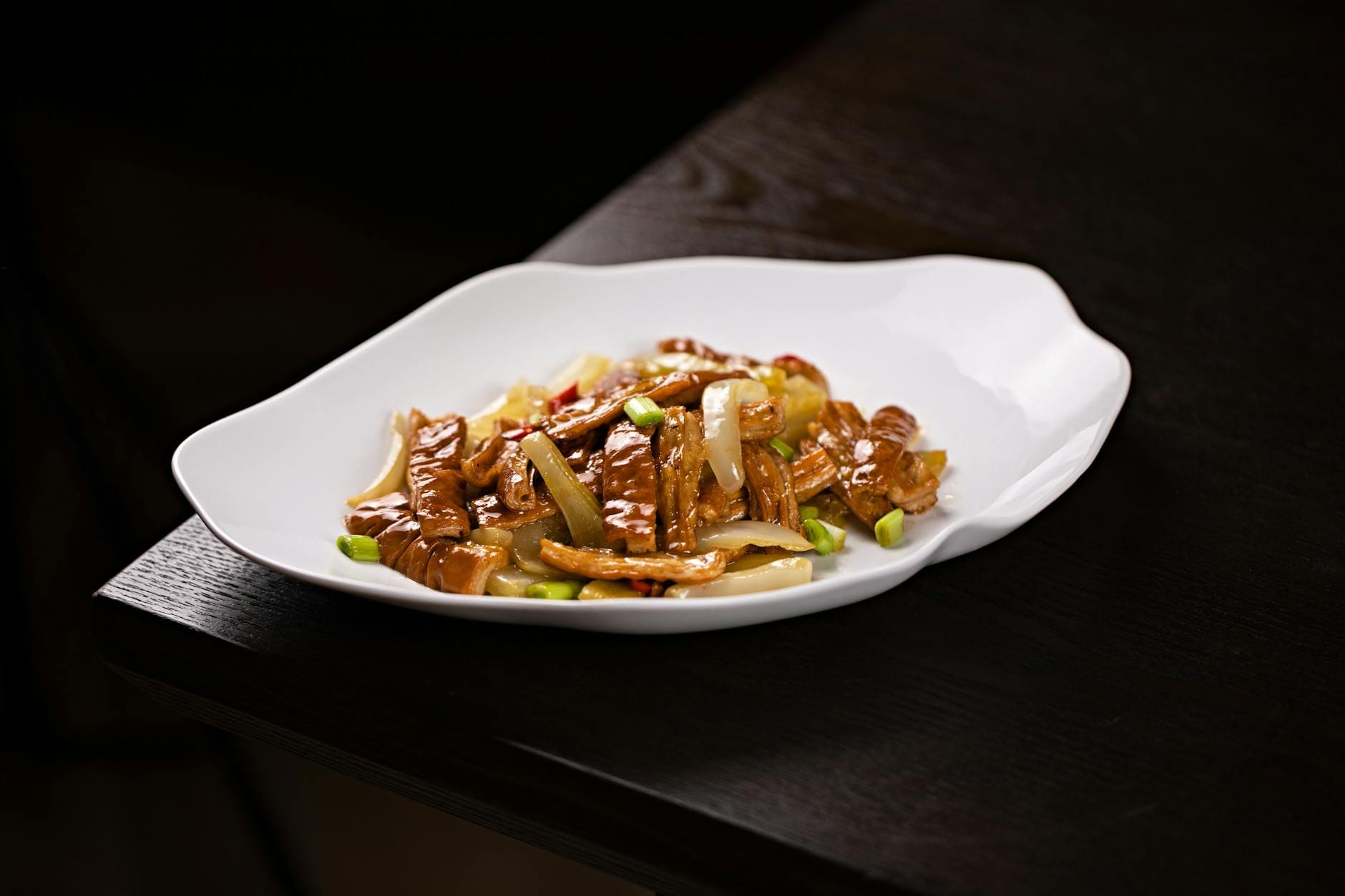 Warzywny stir fry w sosie na białym talerzu, danie z woka