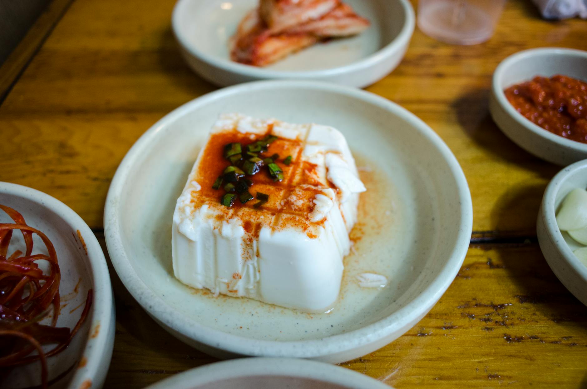 Tofu z warzywami i sosem wśród koreańskich przystawek w restauracji