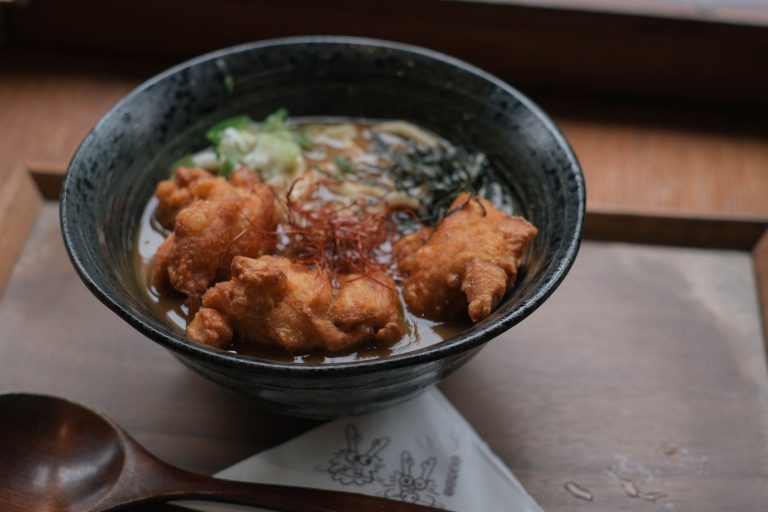Miska ramenu z kurczakiem karaage, bulionem i świeżymi dodatkami